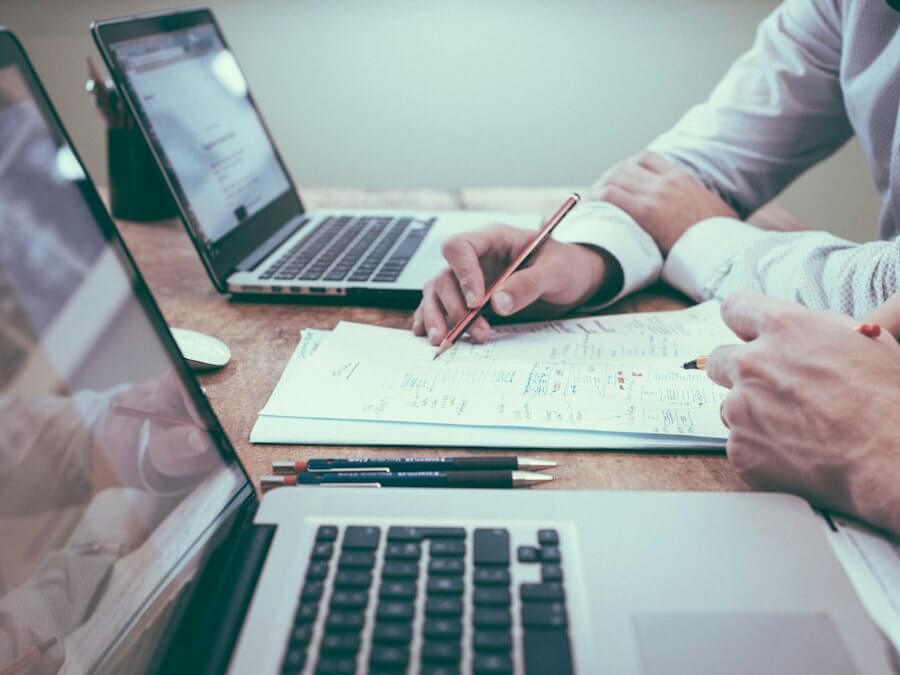 Sessione di coaching opzioni 1 a 1: appunti scritti a mano condivisi al tavolo, con i portatili aperti